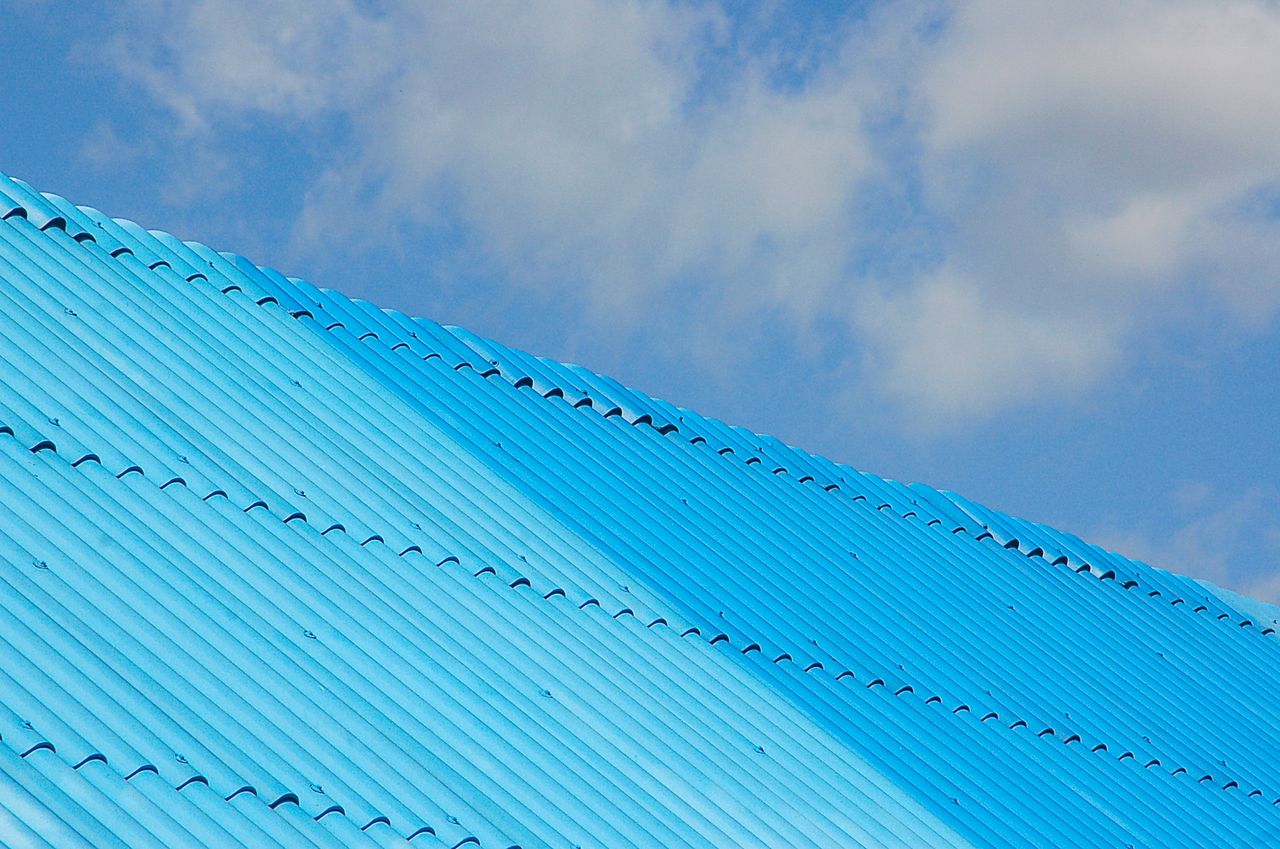 Crafting Captivating Headlines: Your awesome post title goes here A bright blue corrugated roof shot from a low angle against a clear sky.